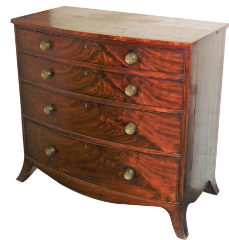 An early 19thC mahogany bow fronted chest of drawers, with a plain top above four graduated drawers, each with brass handles with a chequer banded apron and out swept feet, 101cm high, 105cm wide, 56cm deep.