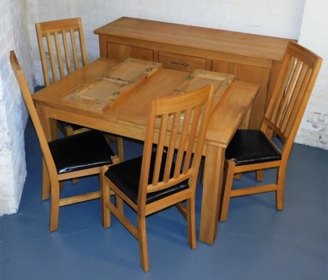 A light oak dining room suite, comprising sideboard, with four drawers flanked by two hinged cupboards, 91cm high, 164cm wide, 53cm deep, an extending dining table, and four chairs, with leatherette drop in seats.