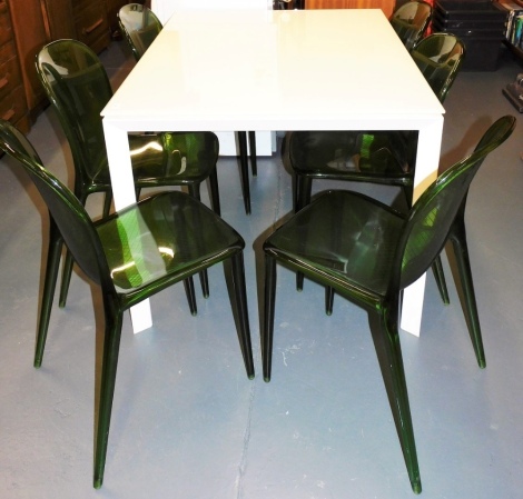 A late 20th/early 21stC white painted metal and glass dining table, 75cm high, the top 90cm x 120cm, and six green moulded Perspex dining chairs, in the manner of Stark.