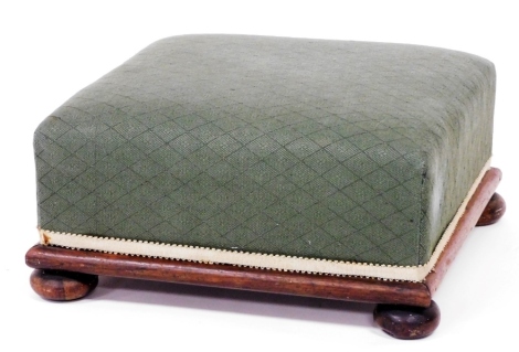 A Victorian mahogany footstool, upholstered in green fabric, on bun feet, 38cm wide.