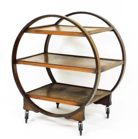 An Art Deco oak three tier trolley, of oval form with castors, 70cm wide.