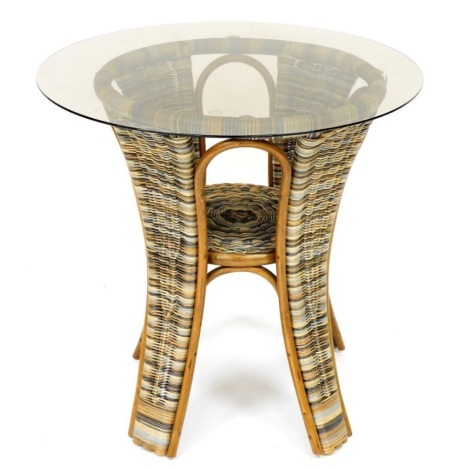 A smoked glass and woven rattan conservatory table, with a circular top and recess, 75cm high, 77cm diameter.