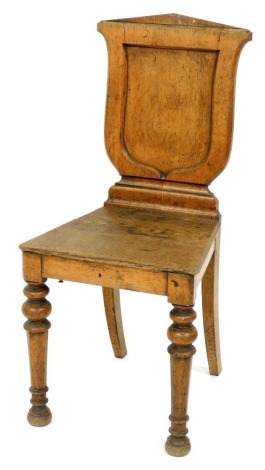 A Victorian oak hall chair, with a panelled shield shaped back, a solid seat on turned tapering legs. (AF)