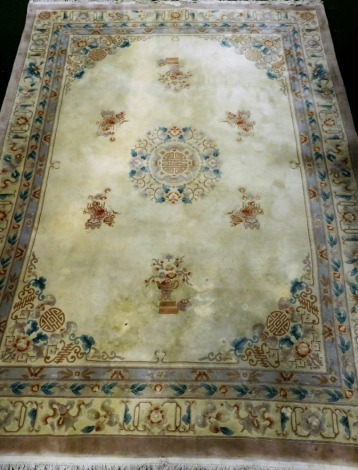 A Chinese cut wool carpet, with the design of flowers, roundels, in pastel colours on a cream ground. 390cm x 275cm..