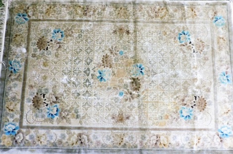 A Chinese silk type rug, with a design of coloured cream flowers, on a cream ground with one wide border, tasseled ends, 190cm x 123cm.