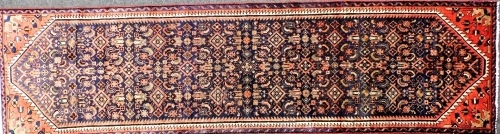 A Persian blue ground runner, decorated with an all over stylised floral decoration, within dog tooth borders, 281cm x 76cm.