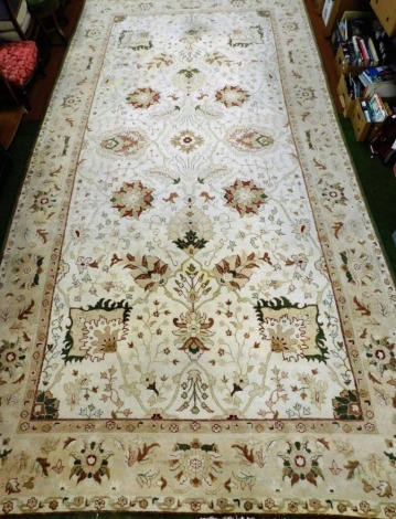 A Ziegler Afghan cream ground rug, decorated with floral and foliate motifs within a repeating floral and green edged border.550cm x 280cm.