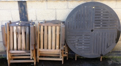 A circular garden table and four associated chairs. - 2