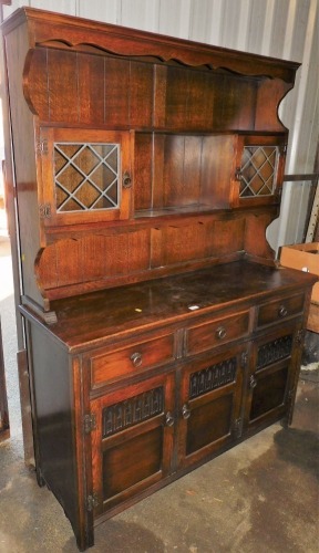 An oak dresser, the base with an arrangement of drawers and cupboards, 182cm high, 130cm wide, 47cm deep.