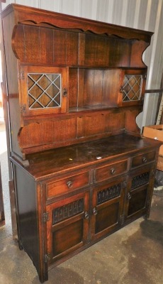 An oak dresser, the base with an arrangement of drawers and cupboards, 182cm high, 130cm wide, 47cm deep.