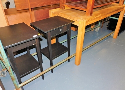 A light oak dining table, with a frieze drawer, the top 70cm x 140cm, and two bedside tables, each with a frieze drawer and under tier, 73cm high.