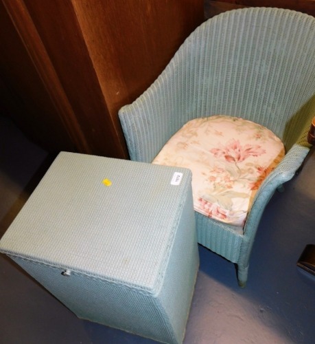 A Lloyd Loom style tub chair, and a lidded laundry basket. The upholstery in this lot does not comply with the 1988 (Fire & Fire Furnishing) Regulations, unless sold to a known exporter or upholsterer it will be cut from the frame before leaving the prem