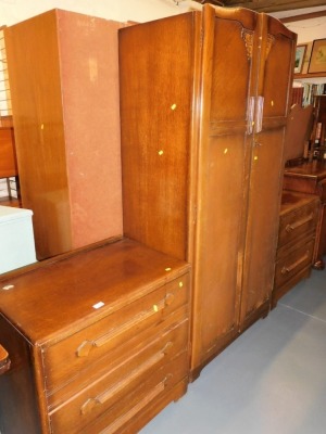 A mid 20thC three piece bedroom suite, comprising double wardrobe, a chest of three drawers, and a mirror back two drawer chest.