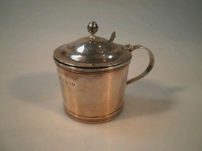 A George III silver cylindrical mustard pot with domed lid with an acorn finial