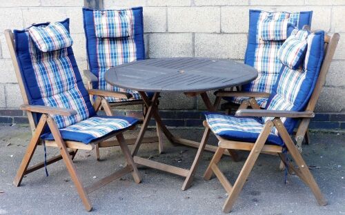 A circular garden table and four associated chairs.