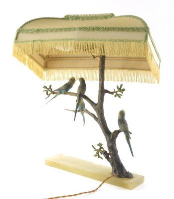 A 1920s cold painted bronze table lamp, set with four budgerigars on entwined floral branches and a green onyx base, 34cm wide, with electrical feature and shade. WARNING! This lot contains untested or unsafe electrical items. It is supplied for scrap o