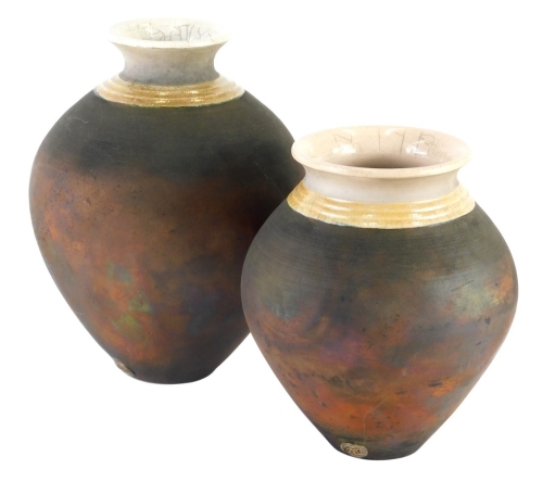 A graduated pair of 20thC Eleanor Newhall Cornish Studio pottery vases, each of tapering circular form, with raku glaze cream necks and matt bodies, 22cm high, etc. (2)