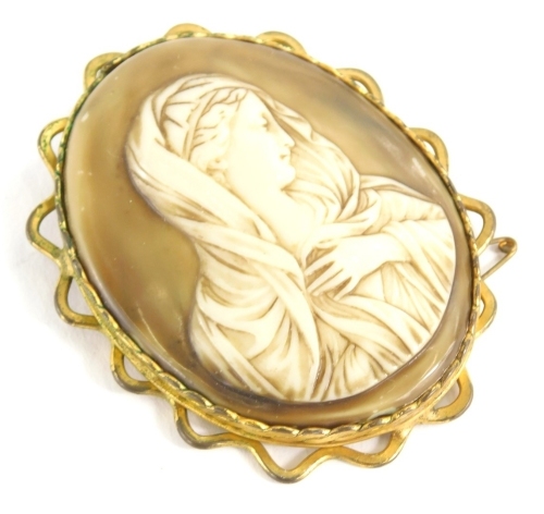 A large religious cameo, of oval form, formed as a lady in flowing robes, quarter profile, in a fancy mount, 9cm high.