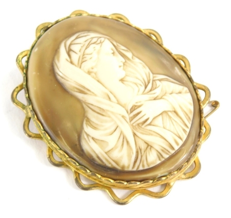 A large religious cameo, of oval form, formed as a lady in flowing robes, quarter profile, in a fancy mount, 9cm high.