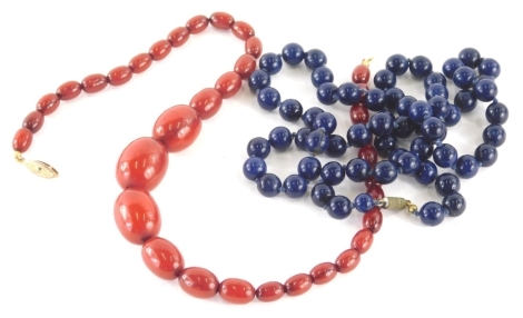A lapis lazuli style necklace, set with uniform beads, 72cm long, with a graduated faux red amber necklace. (2)