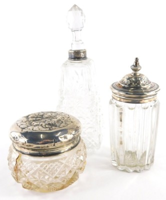 A Victorian silver and cut glass dressing table jar, with pierced silver lid, a further cut glass dressing table jar with silver collar, 19cm high, and a further jar with silver lid. (various dates and makers, 3)
