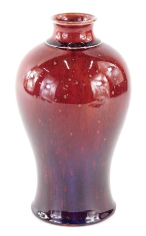 An early 20thC Bernard Moore flambe vase, of inverted shouldered circular form, predominantly in red and blue, printed marks beneath, 22cm high.