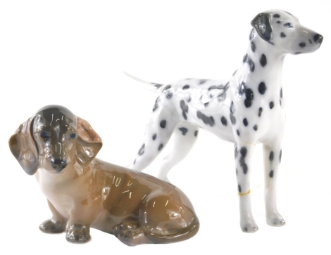 A Royal Copenhagen figure group of a Dalmation standing, 3501, 13cm high, and a seated dachshund. (2 AF)