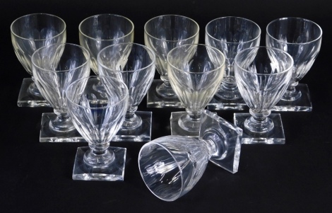 A set of eleven glass rummers, each with shaped tapering bowls on square feet, 11cm high, (11)