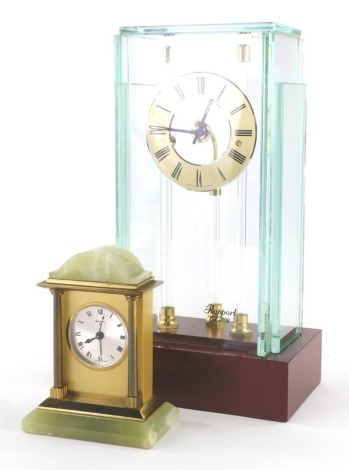 A Rapport mantel clock, with suspended 8cm diameter, Roman Numeric dial, in glazed case on wooden plinth base, 25cm high and a Swiza eight day mantle clock of small proportion, the circular dial flanked by columns in a green marble finish case. (2)