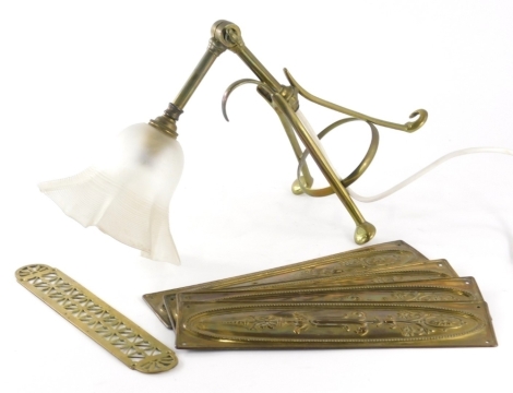 A set of four Edwardian brass finger plates, of rectangular form raised with flowers, 28cm high and a Benson style brass lamp. (5)