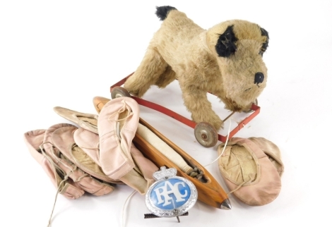 A 1950s plush jointed dog on wheels toy, 26cm high, possibly Mamod and various ballet slippers.