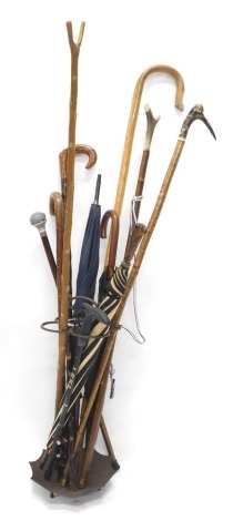 A 20thC iron stick and umbrella stand, in the form of an umbrella with four sections and compressed handle, 72cm high, and various walking sticks, one headed by resin hedgehog, etc. (a quantity)