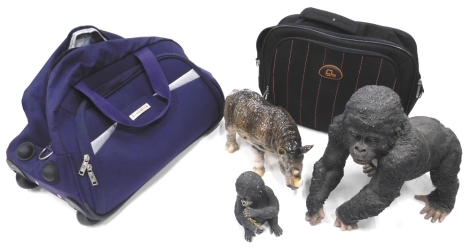 A 20thC resin figure of a gorilla, 25cm high, a pottery SEBC figure of a rhinoceros, and two sports bags.