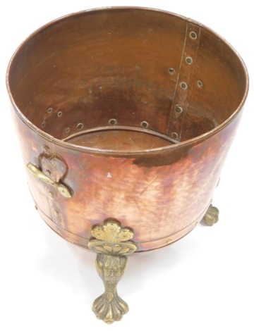 A late 19thC hammered copper coal bucket, with brass mount on hairy paw feet, 39cm high, 42cm wide.