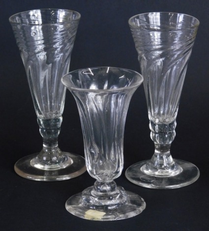 A pair of 19thC dwarf ale glasses, each with swirl bowls, turned stems and polished pontil marks, and a further drinking glass, with flower head base and rough pontil. (3)