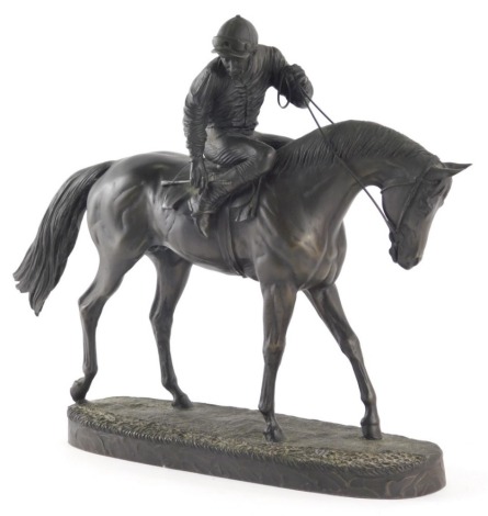 A resin bronze finish figure group of horse and jockey, indistinct label beneath, 18cm high.