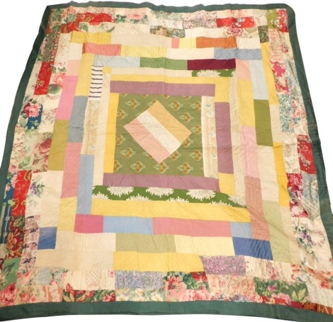 An early 20thC patchwork quilt, of square form with a central white and brown section, 160cm by 146cm.