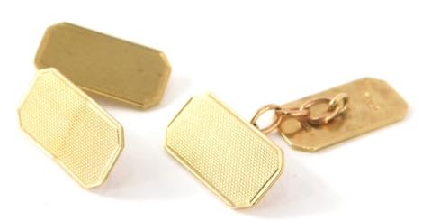 A pair of 9ct gold cufflinks, engine turned with canted corners and chain centres, 2cm high, 5g. (2)