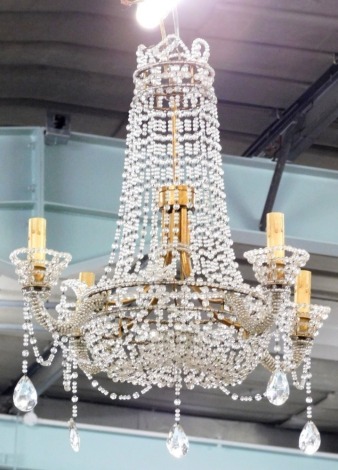 A four branch gilt metal chandelier, suspended with cut glass beads, 64cm high, 57cm wide.