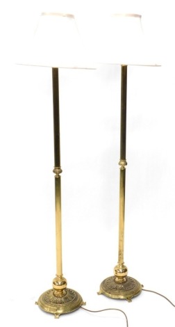 A pair of brass column floor lamps, each on a circular base, 155cm high overall. (2)