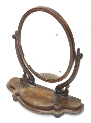 A Victorian mahogany dressing table mirror, the oval plate on shaped supports the moulded base with a hinged trinket circular on tapering feet, 74cm wide.