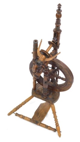 A 20thC spinning wheel, with turned frame, articulated wheel and triple turned legs with foot pedal beneath, dated 1889, 90cm high.