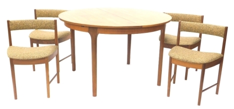 A McIntosh teak extending dining table, on turned legs and four McIntosh chairs, stamped, chair number 9533, the table 123cm diameter enclosed. The upholstery in this lot does not comply with the 1988 (Fire & Fire Furnishing) Regulations, unless sold to a