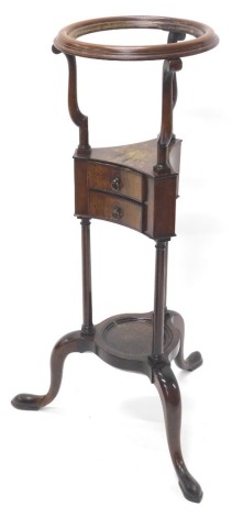 A George III mahogany wash stand, the circular top with a moulded recess for a bowl, above two frieze drawers and an under tier on part turned shaped supports with tripod base terminating in pad feet, 81cm high, the top 27cm diameter. (AF)