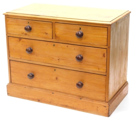 A pine chest of drawers, the top with a moulded edge above two short and two long drawers, each with turned wood handles on a plinth, 74cm high, 93cm wide, 46cm deep.