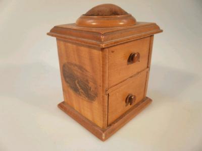 A wooden Mauchline ware pin cushion in the form of a tiny chest of drawers