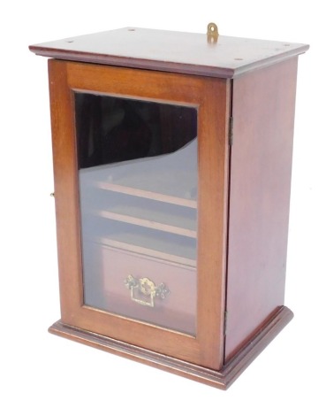 A Victorian mahogany smoker's cabinet, with out swept pediment above a glazed door enclosing two sliding shelves and a single drawer, 32cm high, 23cm wide, 17cm deep.