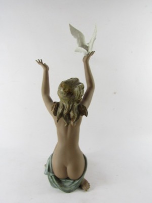 A Lladro matt porcelain figure of a nude lady, modelled kneeling holding aloft a dove, no 3559, printed and impressed marks, 53cm high. (AF) - 3