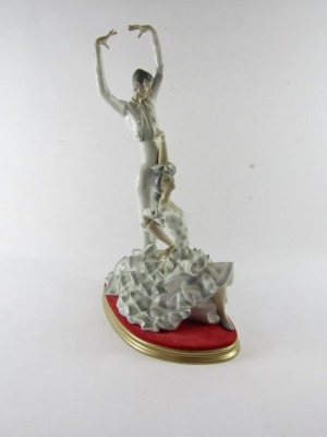 A Lladro porcelain figure group of flamenco dancers, depicting a man, and woman in a polka dot dress, impressed and printed marks, on a gold finish and velvet cushion base, 51cm high. - 2