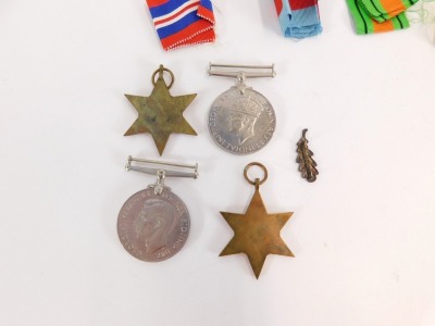 A group of WWII medals, comprising The Africa Star, The 1939-1945 Star, The Defence Medal, and War Medal with oak leaf clasp, with ribbons, and compliment slip from the Under Secretary of State for War. - 2